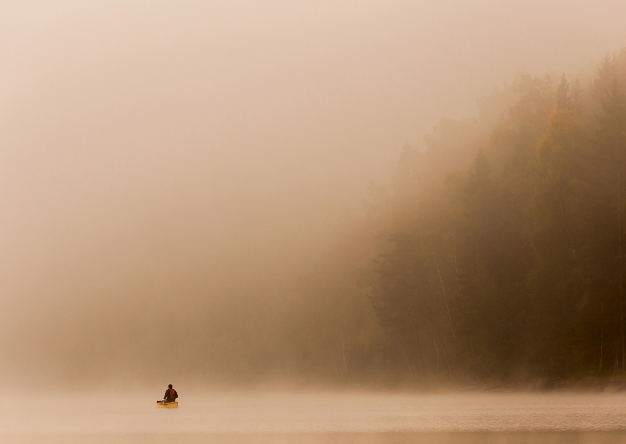 En man i kanot i vacker miljö