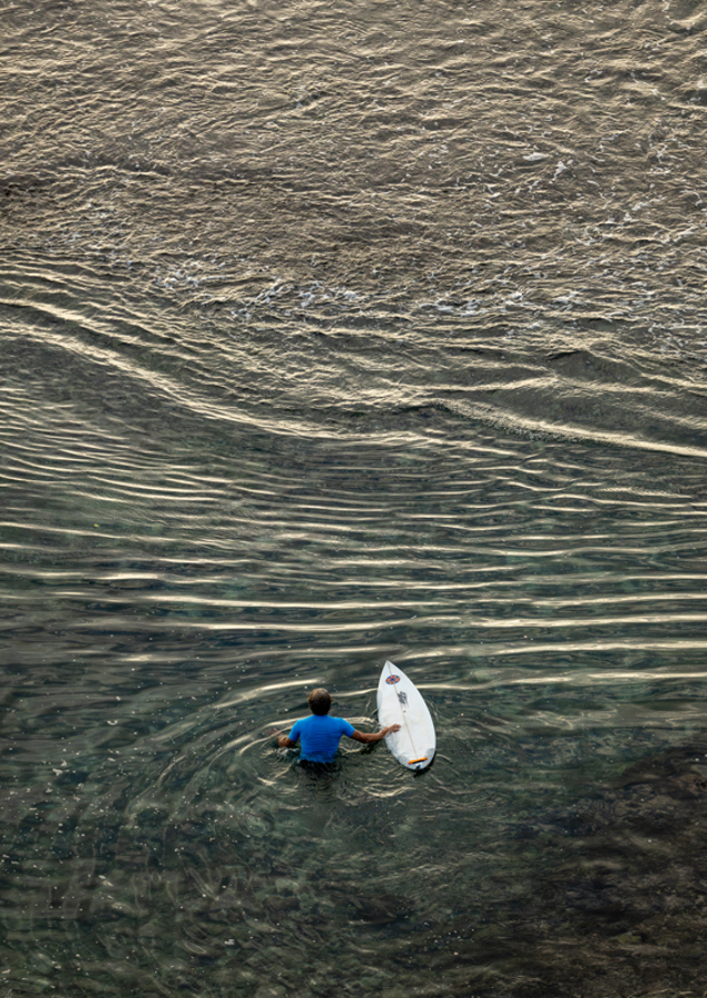Surfer walking over the reef